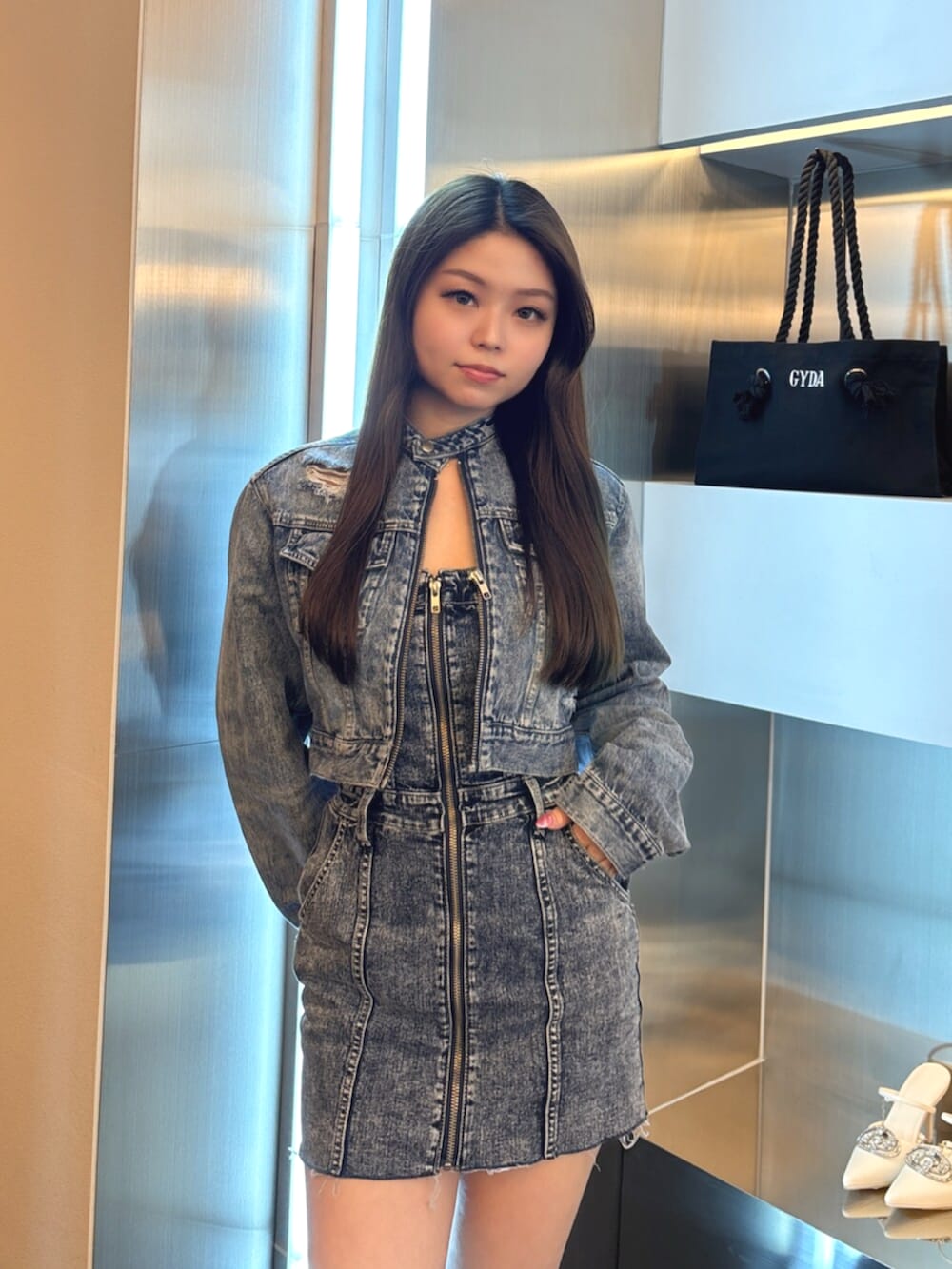 ブラック系のブーツ、ブルー系のワンピース、ブルー系のデニムジャケットを着用したレディースの春コーディネートの4枚目の写真