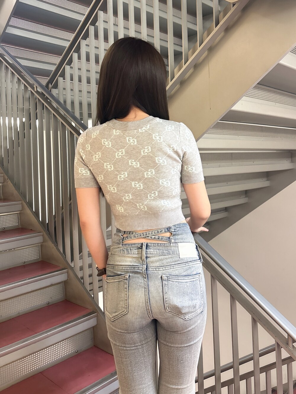 グレー系のニット/セーター、ブルー系のデニムパンツ、ブラック系のサンダルを着用したレディースの春コーディネートの6枚目の写真