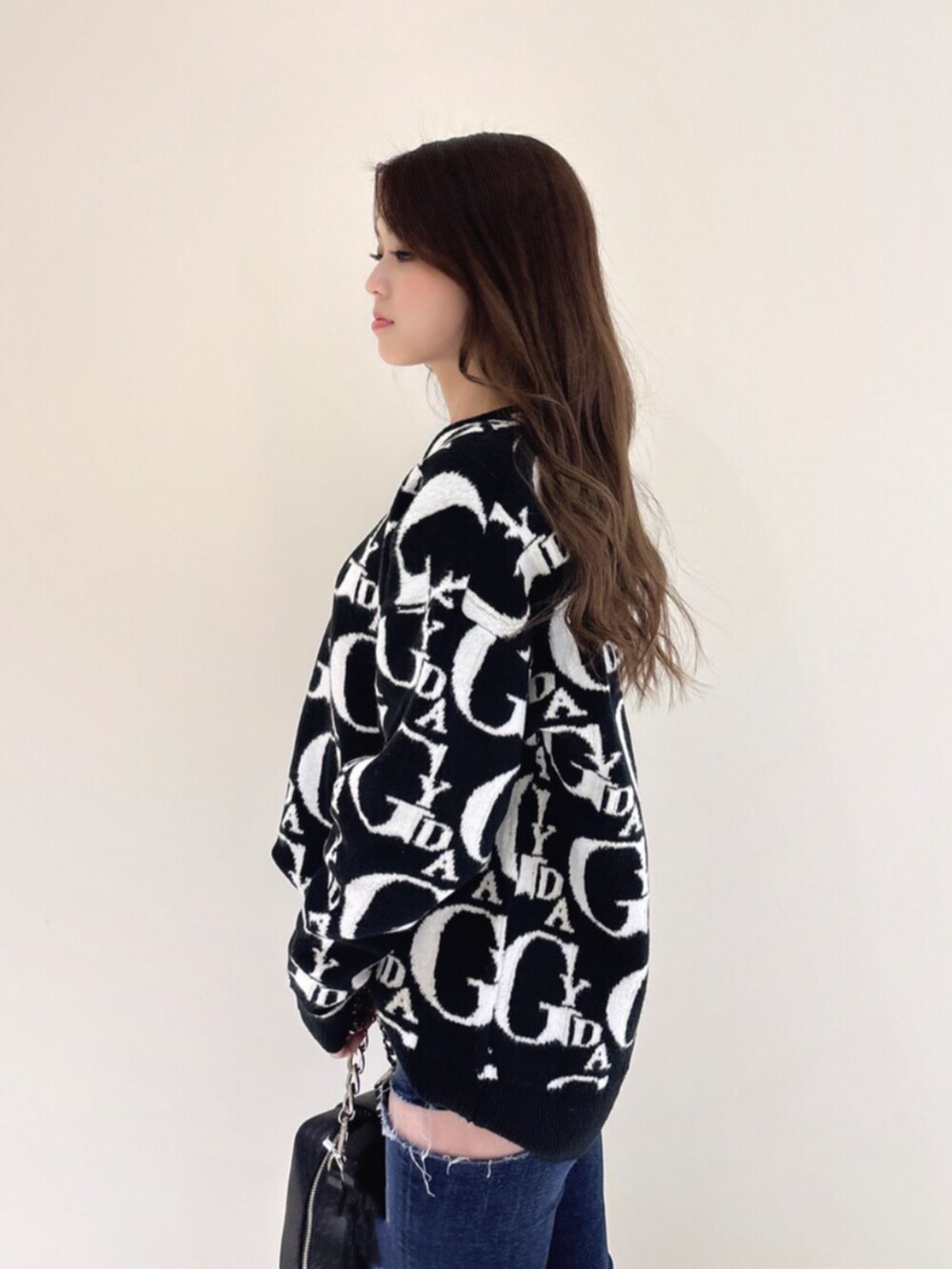 ホワイト系のパンプス、ブラック系のニット/セーター、ブルー系のデニムパンツを着用したレディースの冬コーディネートの7枚目の写真