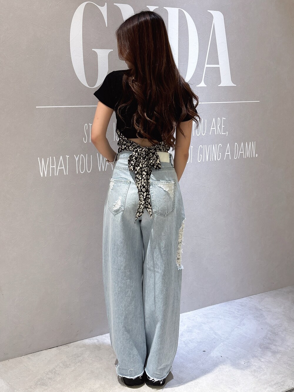 ブラック系のTシャツ/カットソー、ブルー系のデニムパンツ、ブラック系のサンダルを着用したレディースの夏コーディネートの3枚目の写真