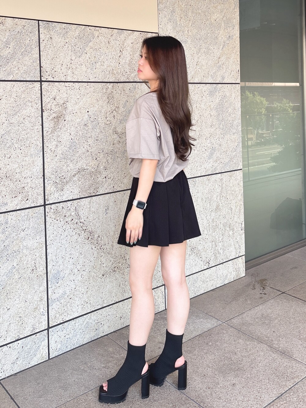 ベージュ系のTシャツ/カットソー、ブラック系のスカート、ブラック系のブーツを着用したレディースの夏コーディネートの3枚目の写真