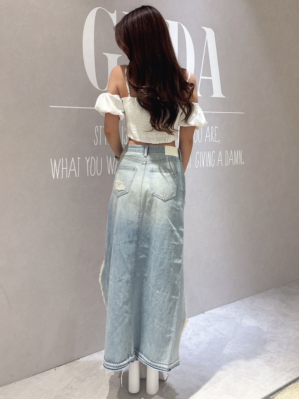 ホワイト系のシャツ/ブラウス、ブルー系のデニムスカート、ブラック系のサンダルを着用したレディースの春コーディネートの3枚目の写真