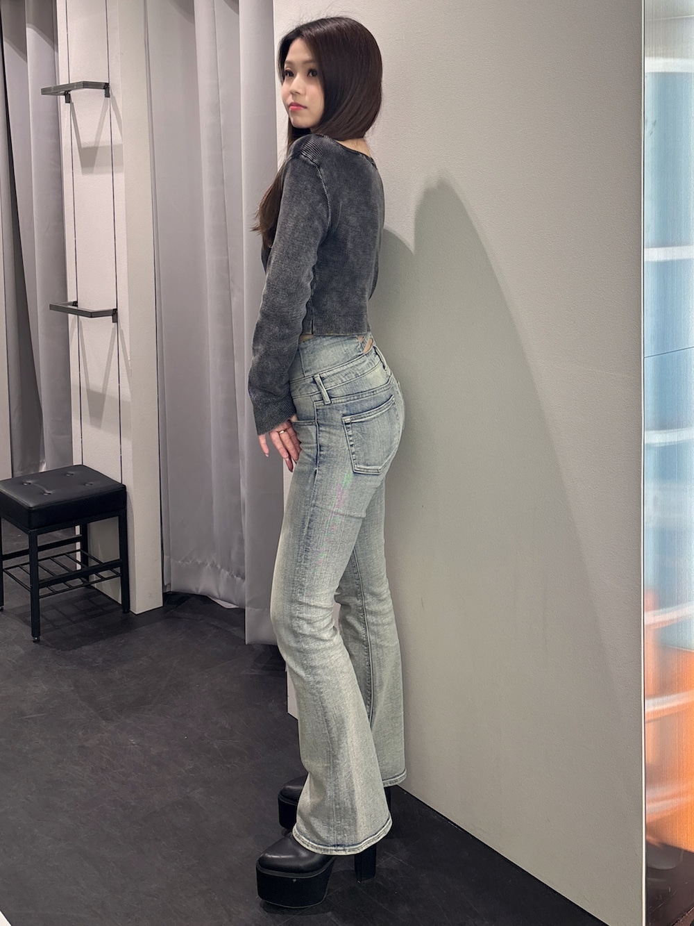 ブラック系のニット/セーター、ブルー系のデニムパンツ、ブラック系のブーツを着用したレディースの春コーディネートの2枚目の写真