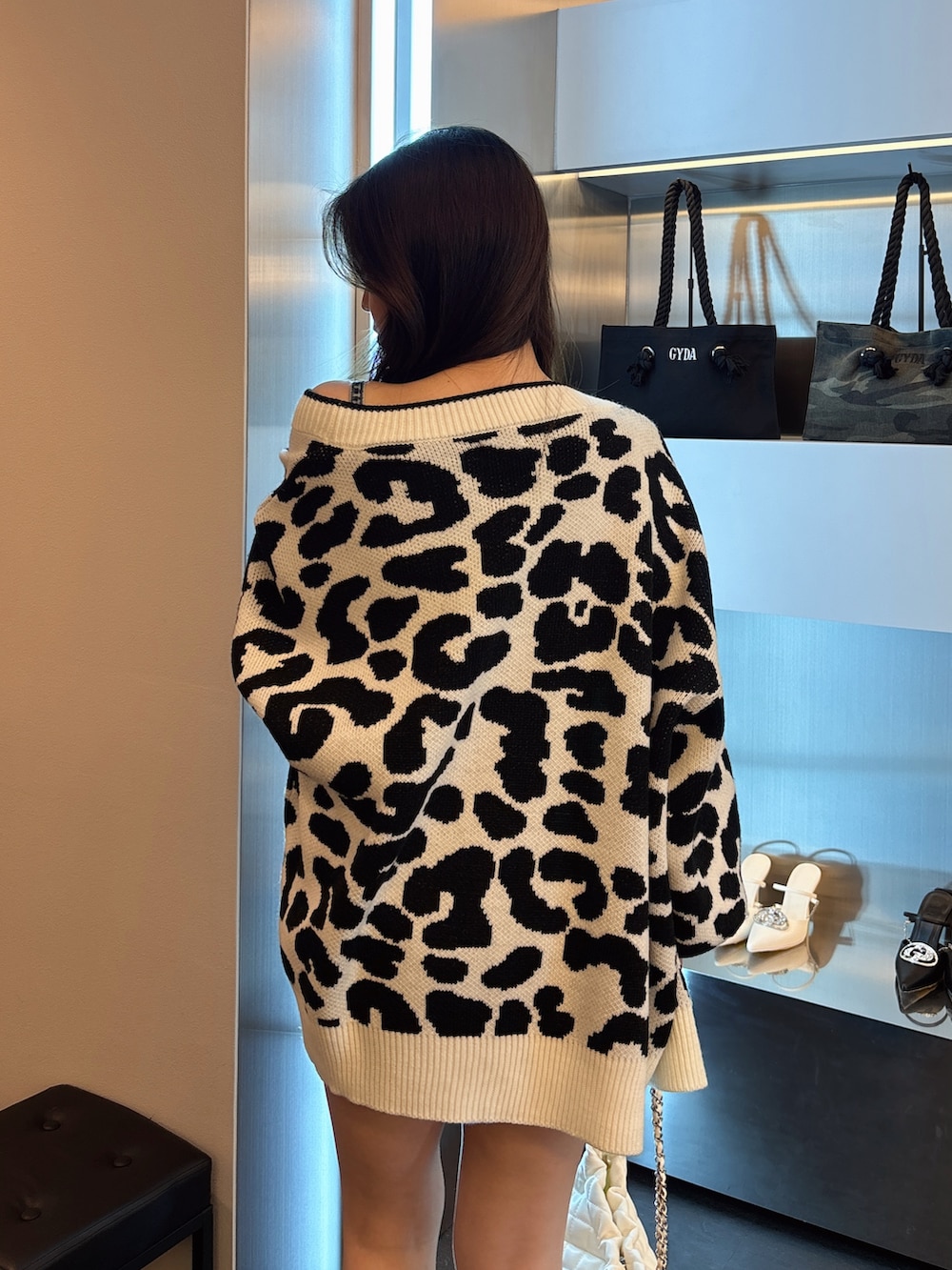 ブルー系のワンピース、ホワイト系のカーディガン/ボレロ、ブラック系のブーツを着用したレディースの春コーディネートの6枚目の写真