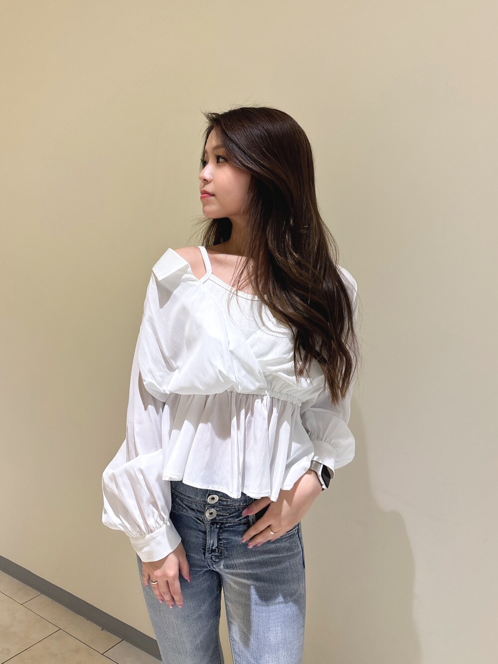 ホワイト系のシャツ/ブラウス、ブルー系のデニムパンツ、ホワイト系のパンプスを着用したレディースの冬コーディネートの8枚目の写真