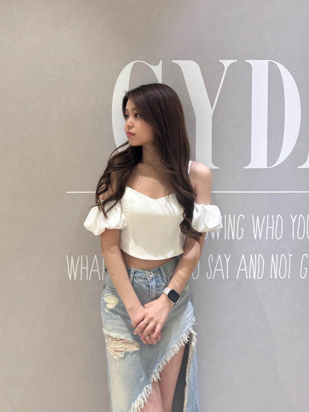 ホワイト系のシャツ/ブラウス、ブルー系のデニムスカート、ブラック系のサンダルを着用したレディースの春コーディネートの5枚目の写真