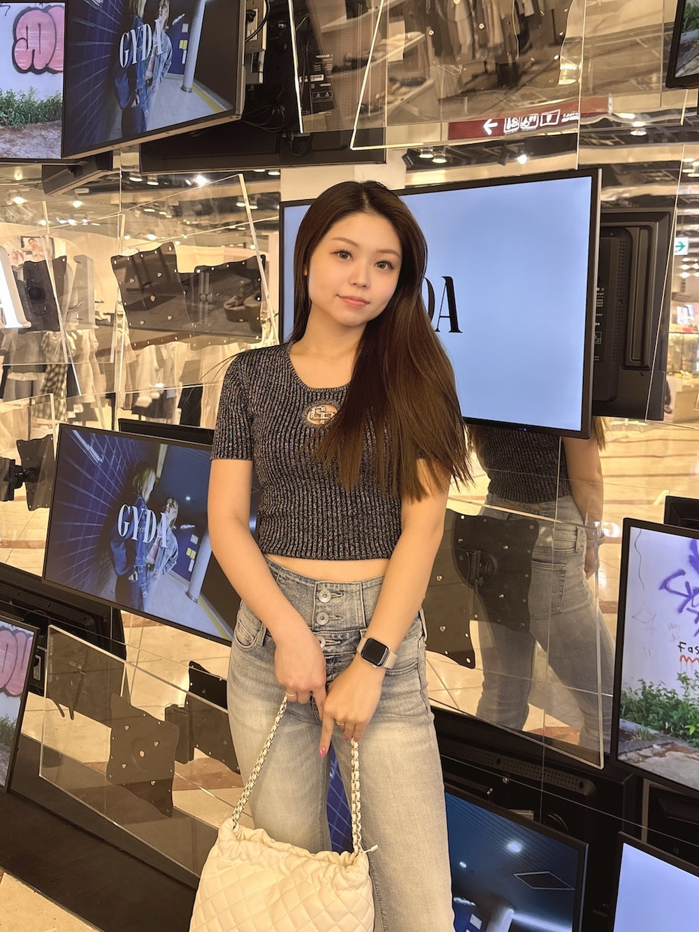 ブラック系のニット/セーター、ブルー系のデニムパンツ、ブラック系のブーツを着用したレディースの春コーディネートの4枚目の写真