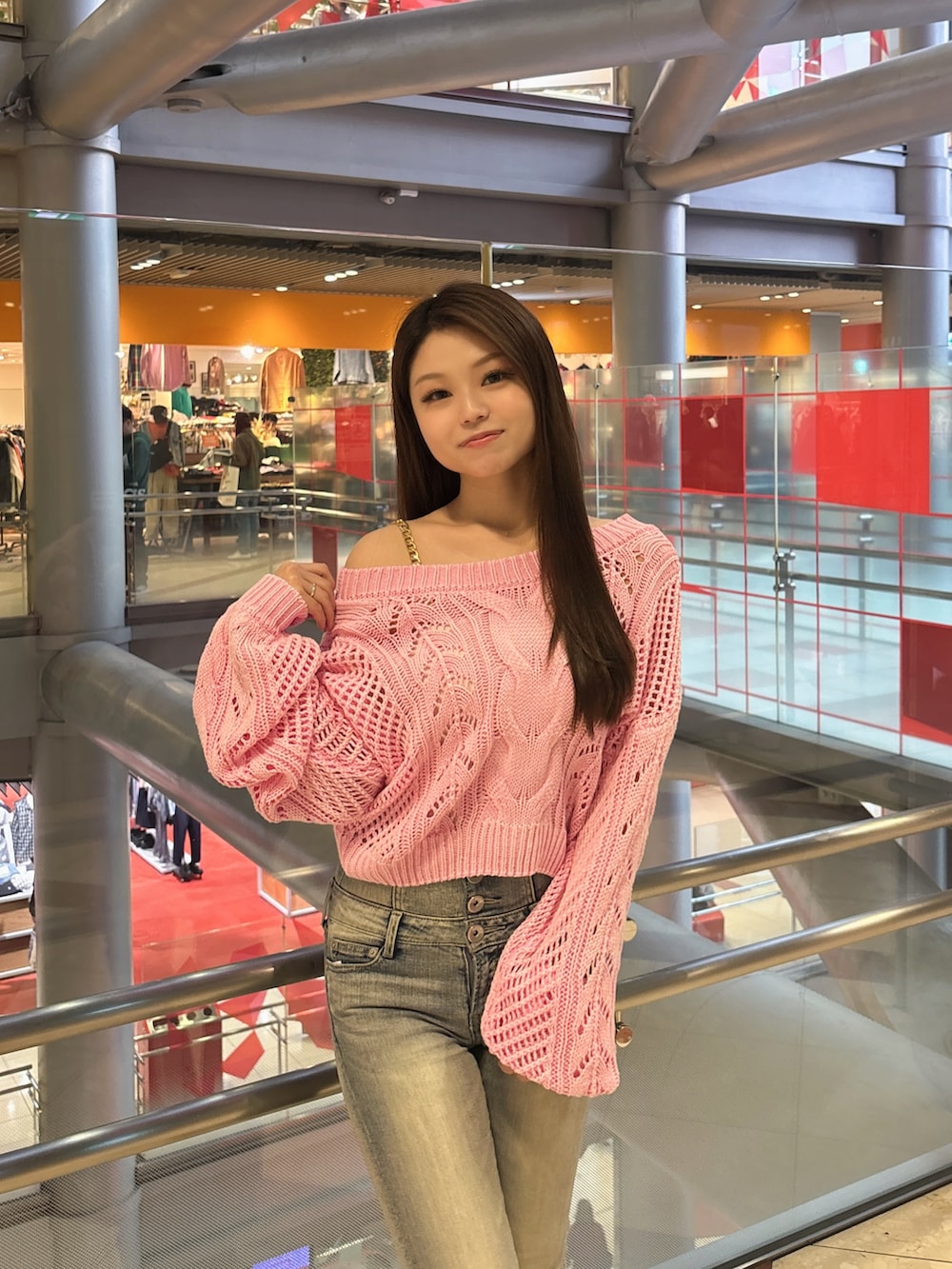 ピンク系のニット/セーター、ホワイト系のキャミソール、ブルー系のデニムパンツを着用したレディースの春コーディネートの4枚目の写真