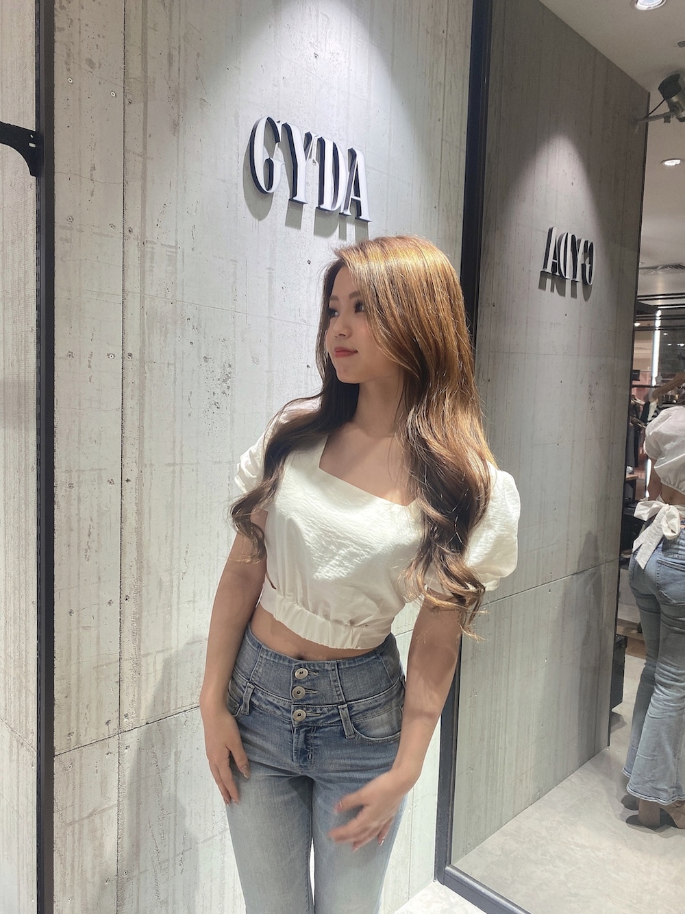 ホワイト系のシャツ/ブラウス、ブルー系のデニムパンツ、ホワイト系のサンダルを着用したレディースの夏コーディネートの3枚目の写真