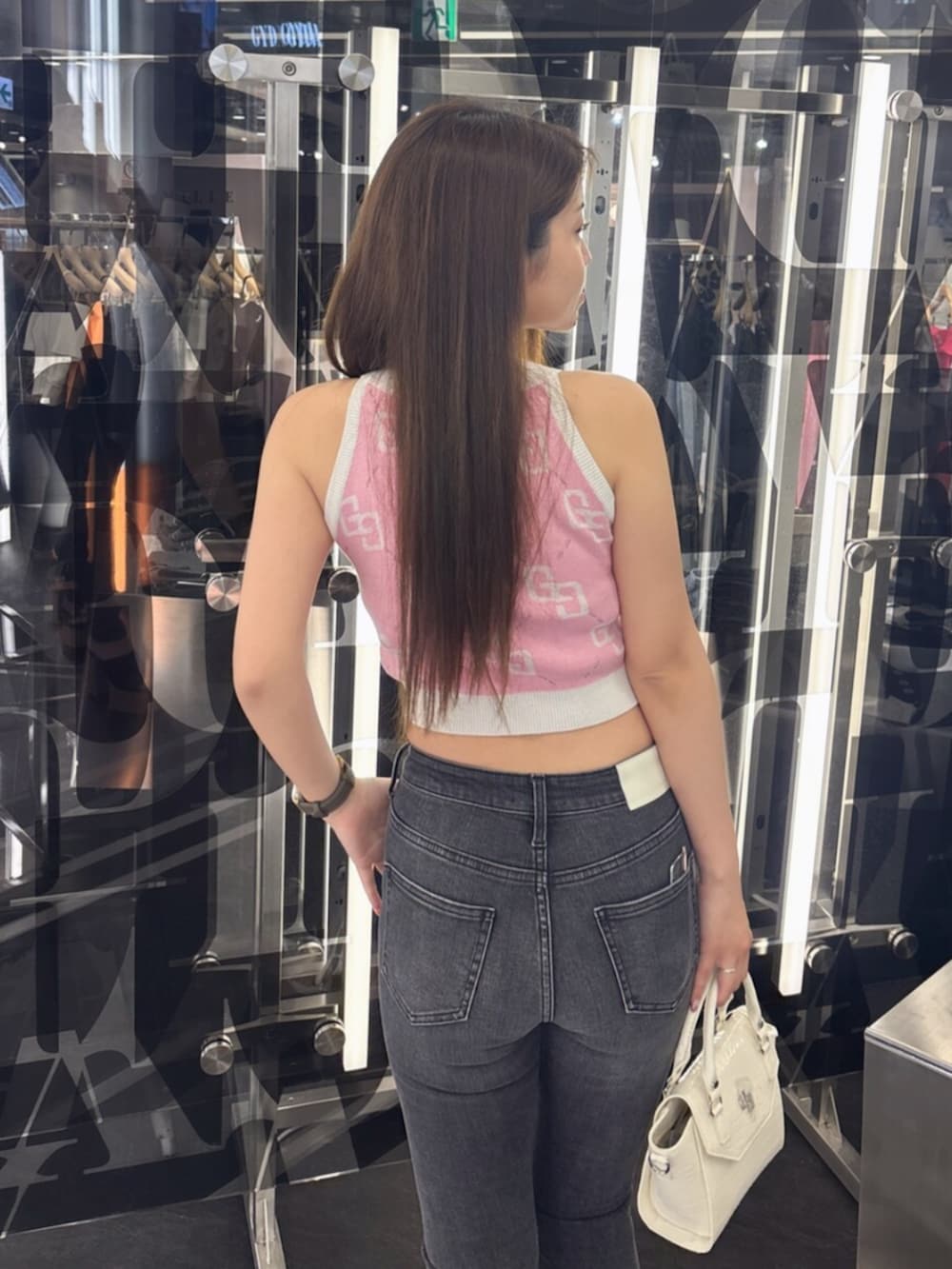 ホワイト系のサンダル、ブラック系のデニムパンツ、ホワイト系のハンドバッグを着用したレディースの夏コーディネートの6枚目の写真
