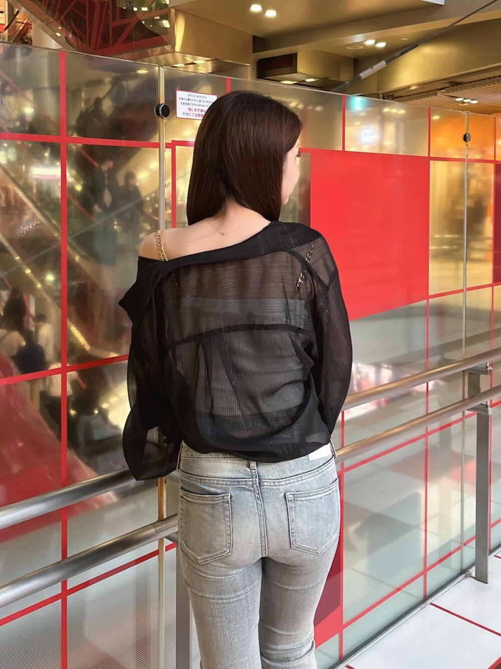 ブラック系のブーツ、ブルー系のデニムパンツ、ホワイト系のキャミソールを着用したレディースの春コーディネートの6枚目の写真