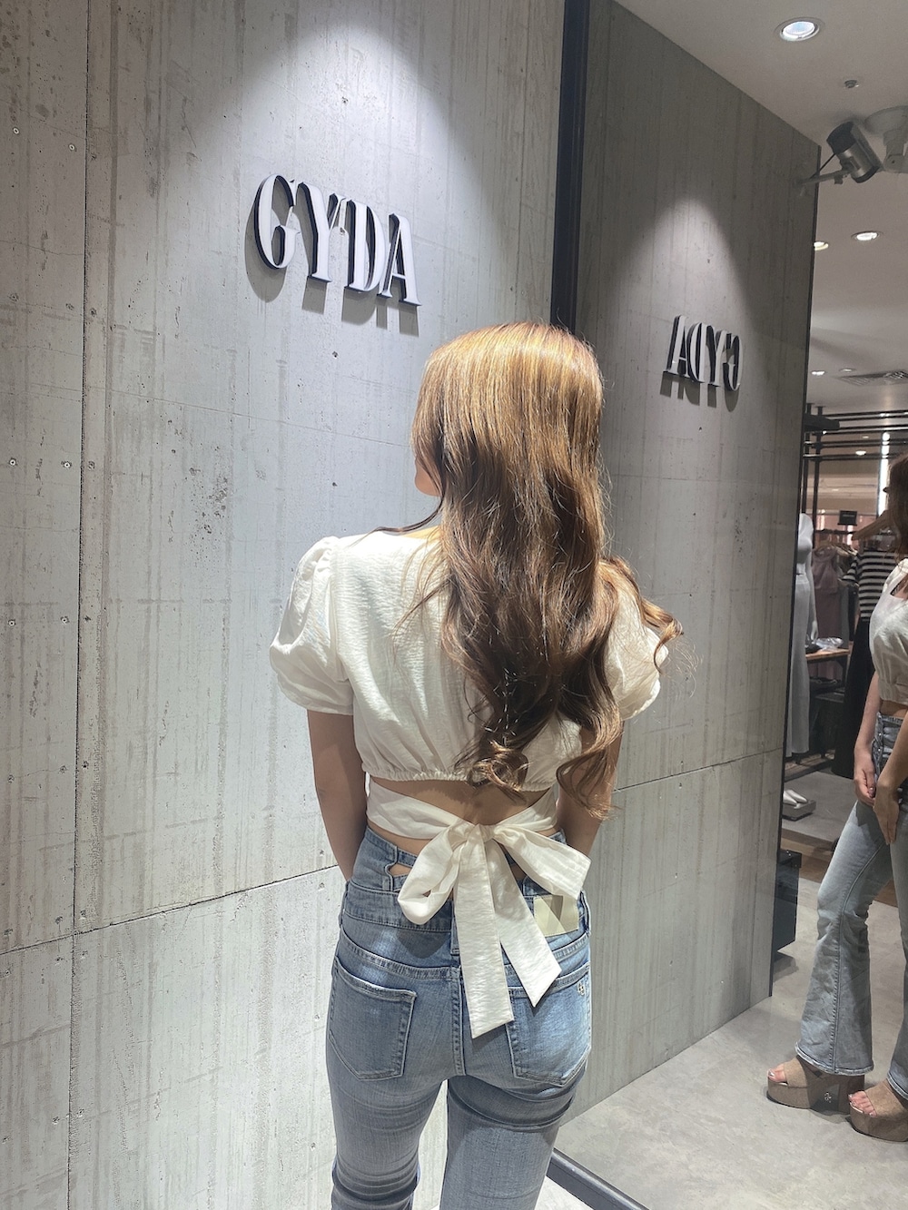 ホワイト系のシャツ/ブラウス、ブルー系のデニムパンツ、ホワイト系のサンダルを着用したレディースの夏コーディネートの5枚目の写真