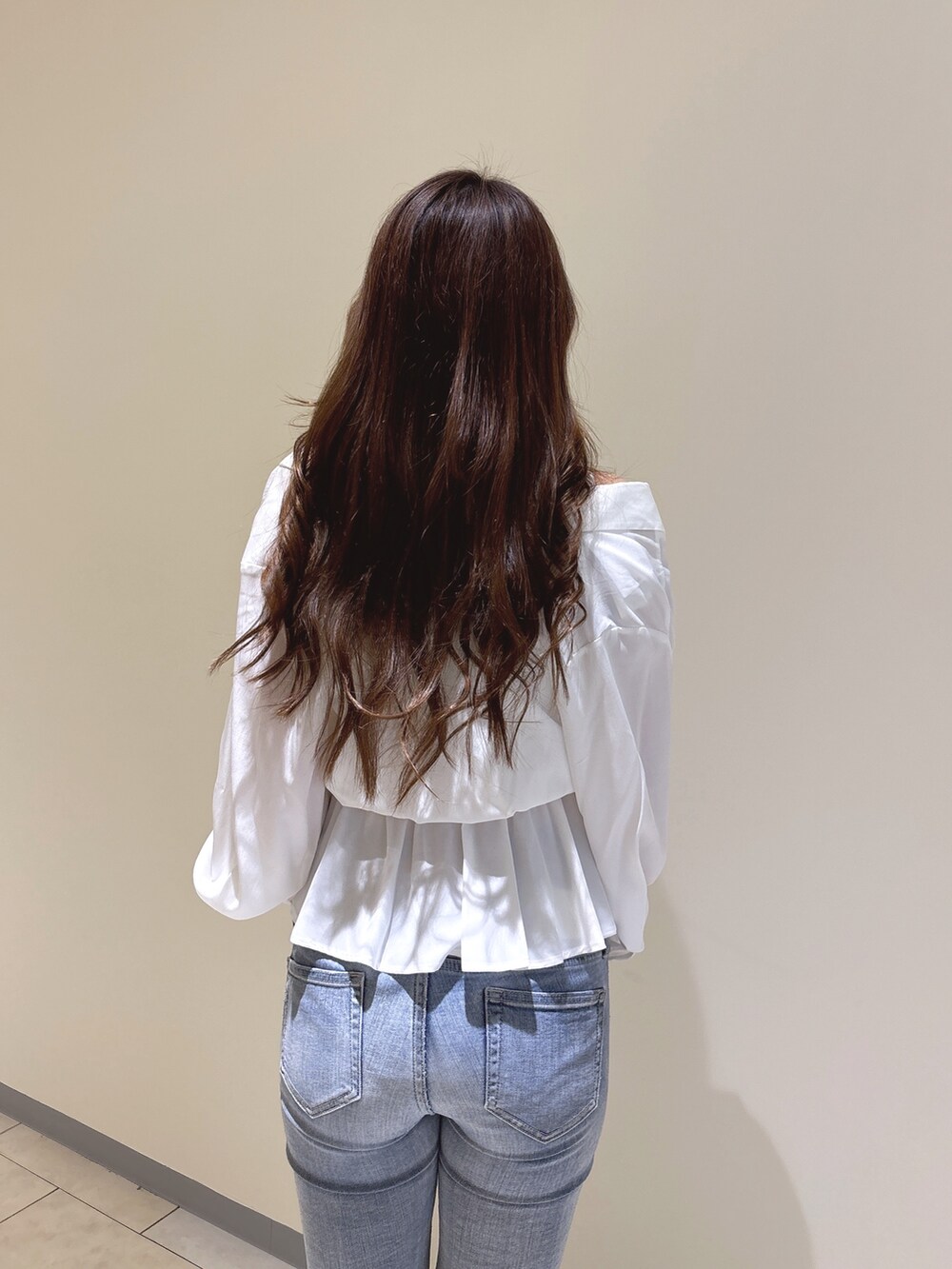 ホワイト系のシャツ/ブラウス、ブルー系のデニムパンツ、ホワイト系のパンプスを着用したレディースの冬コーディネートの10枚目の写真