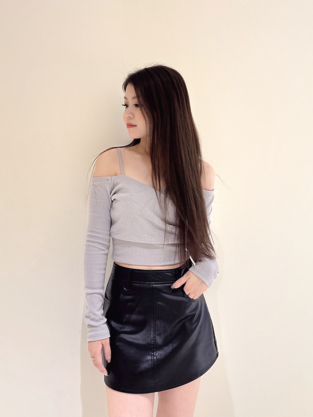 グレー系のTシャツ/カットソー、ブラック系のスカート、ブラック系のブーツを着用したレディースの秋コーディネートの6枚目の写真