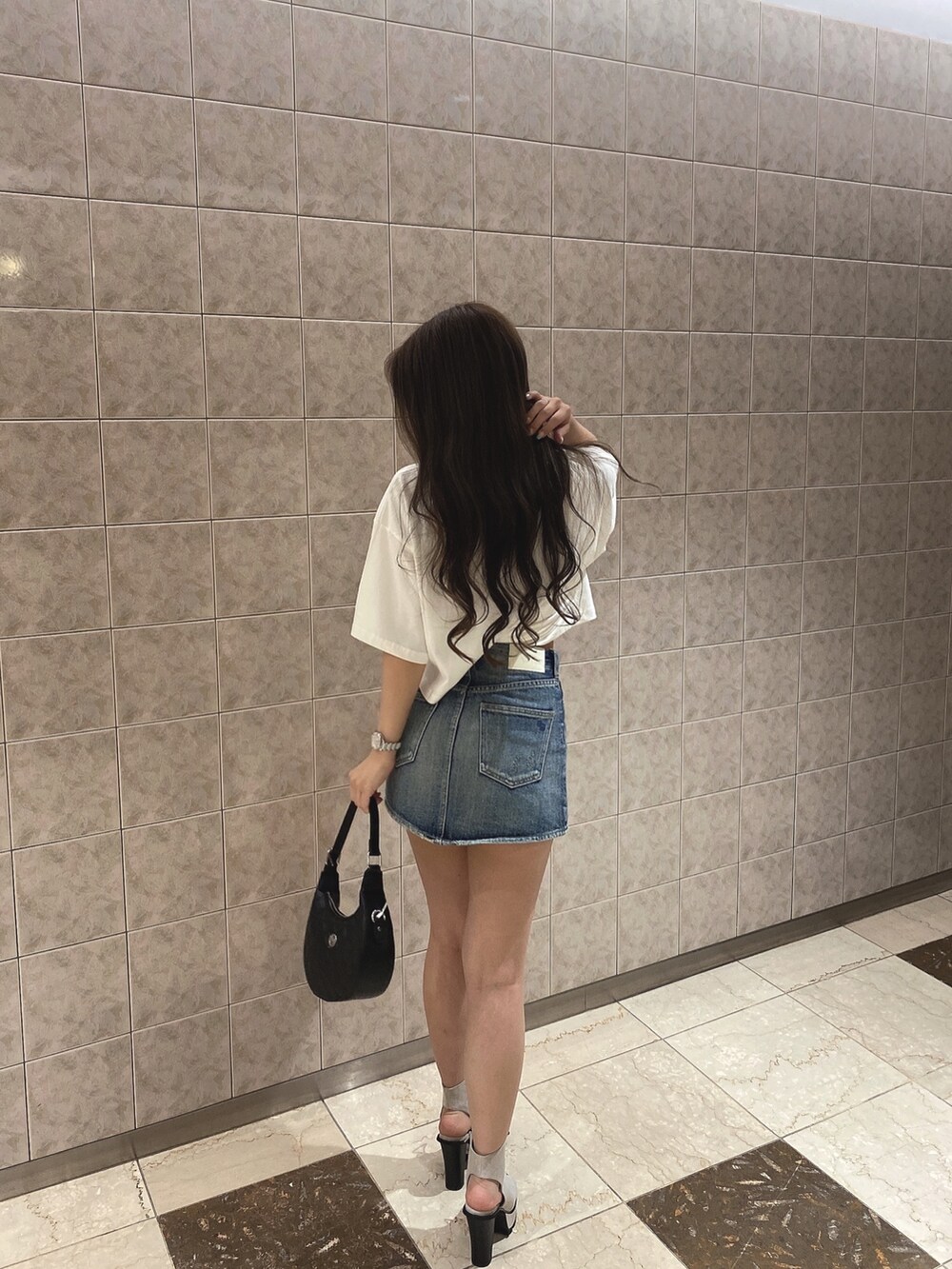 ホワイト系のTシャツ/カットソー、ブルー系のデニムスカート、ホワイト系のブーツを着用したレディースの夏コーディネートの3枚目の写真