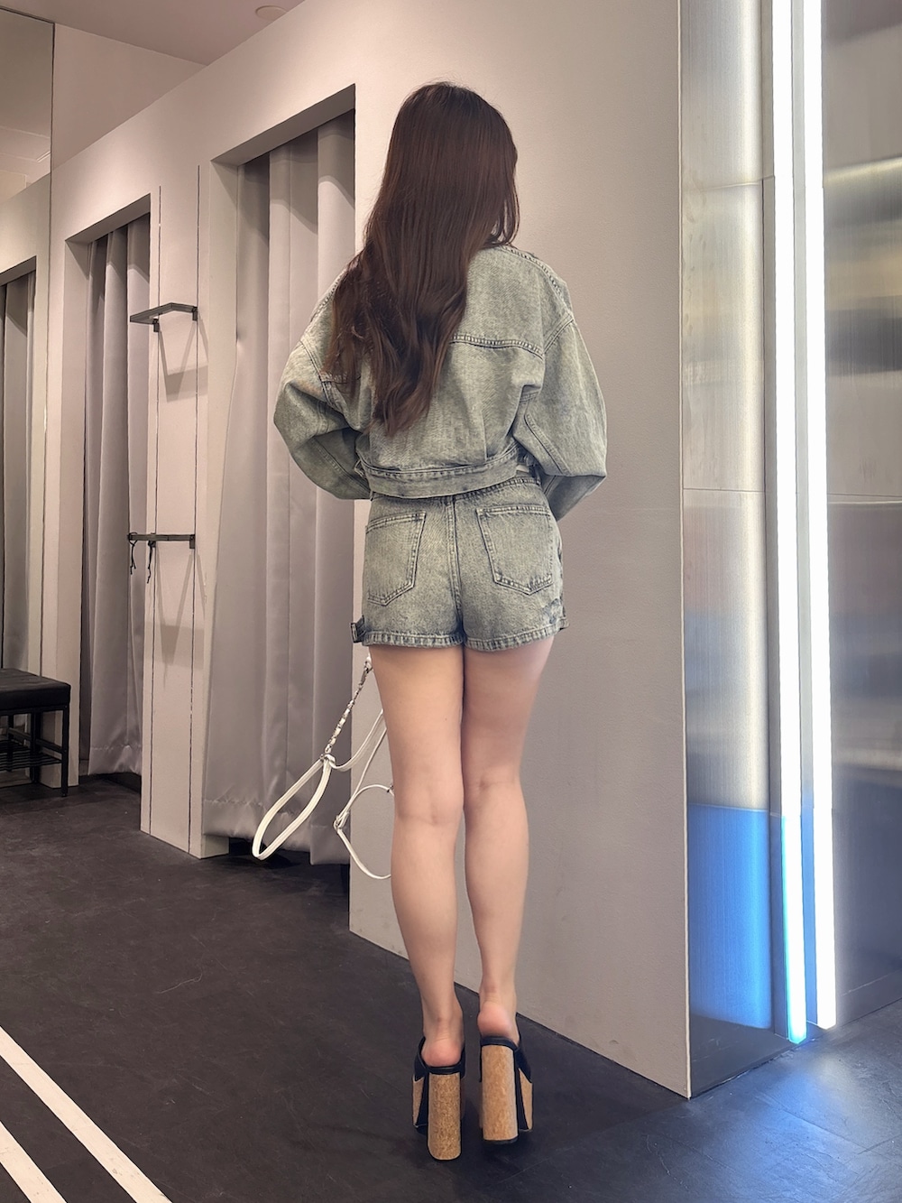 ブルー系のデニムジャケット、ブルー系のデニムパンツ、ホワイト系のバックパック/リュックを着用したレディースの夏コーディネートの3枚目の写真