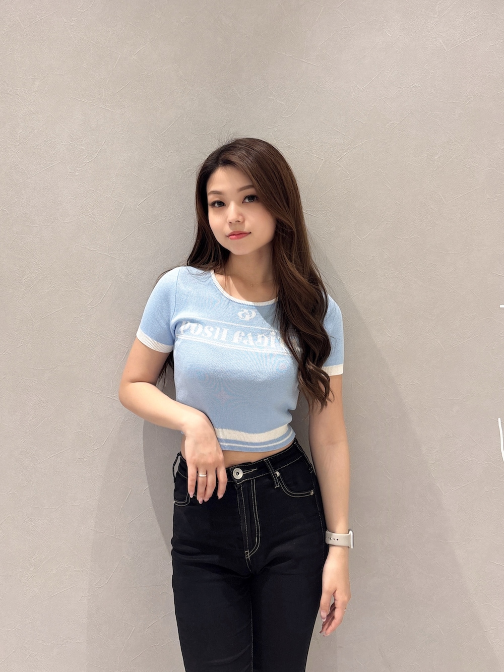 ブルー系のニット/セーター、ブラック系のデニムパンツ、ホワイト系のパンプスを着用したレディースの春コーディネートの4枚目の写真