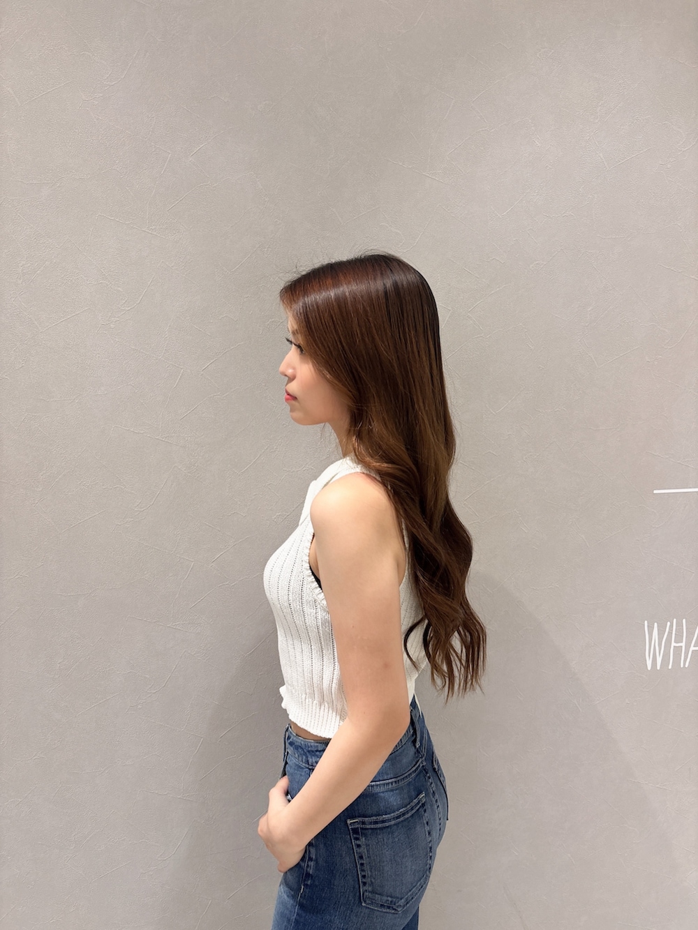 ホワイト系のニット/セーター、ブルー系のデニムパンツ、ホワイト系のパンプスを着用したレディースの夏コーディネートの5枚目の写真