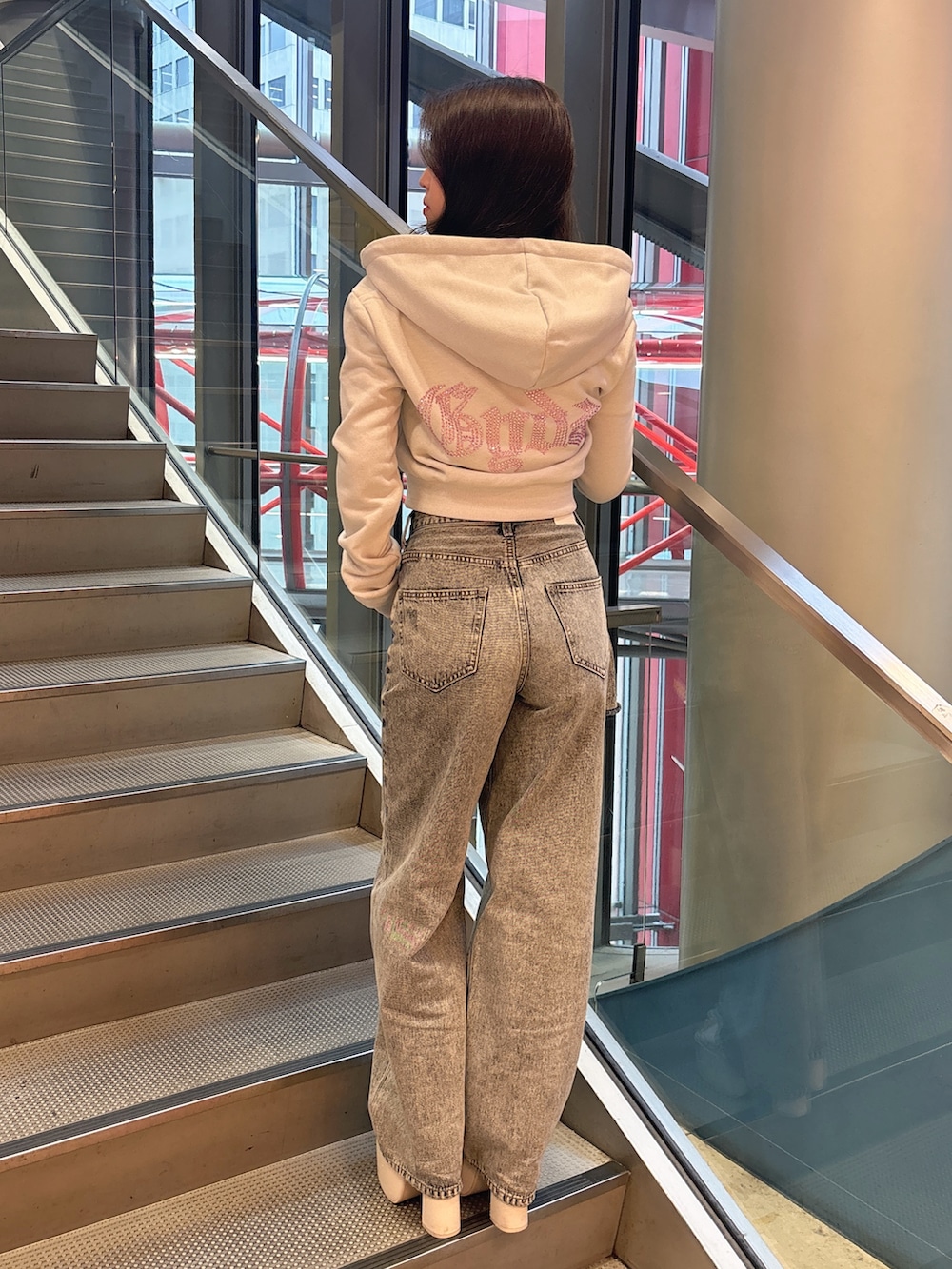 ホワイト系のパーカー、ブルー系のデニムパンツ、ホワイト系のサンダルを着用したレディースの春コーディネートの3枚目の写真