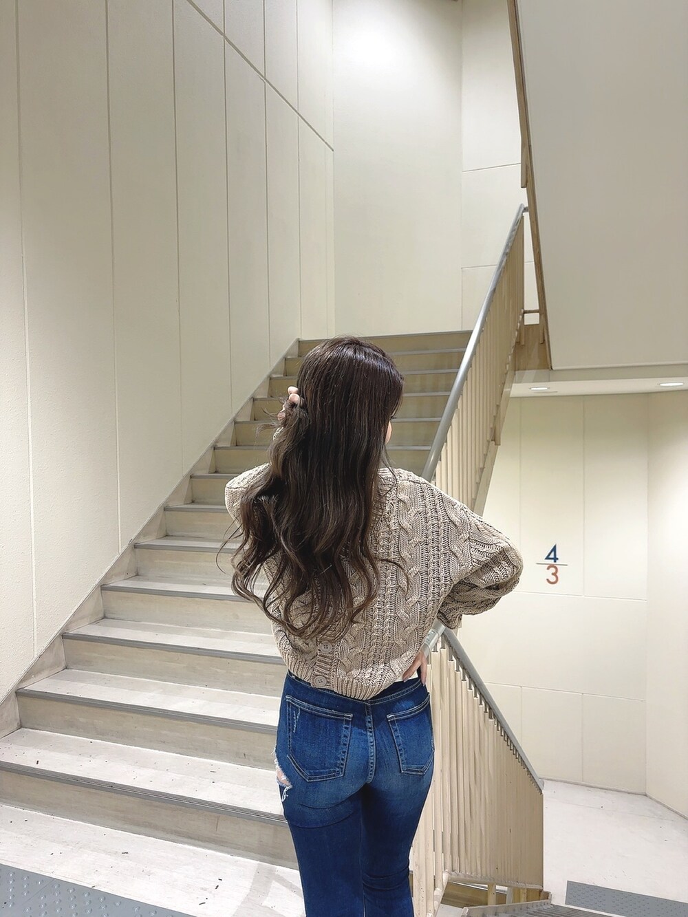 ベージュ系のニット/セーター、ブルー系のデニムパンツ、ホワイト系のパンプスを着用したレディースの冬コーディネートの5枚目の写真