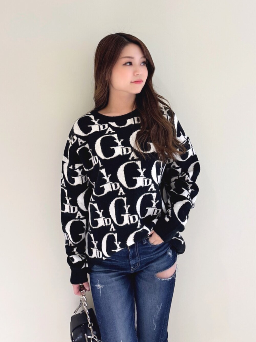 ホワイト系のパンプス、ブラック系のニット/セーター、ブルー系のデニムパンツを着用したレディースの冬コーディネートの5枚目の写真