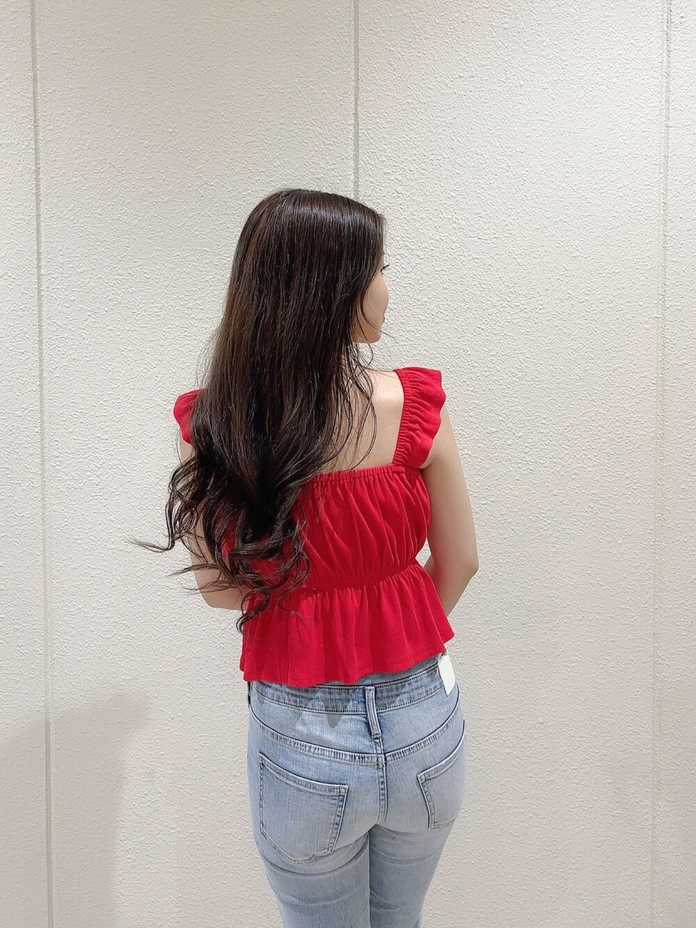 レッド系のTシャツ/カットソー、ブルー系のデニムパンツ、ホワイト系のサンダルを着用したレディースの春コーディネートの8枚目の写真