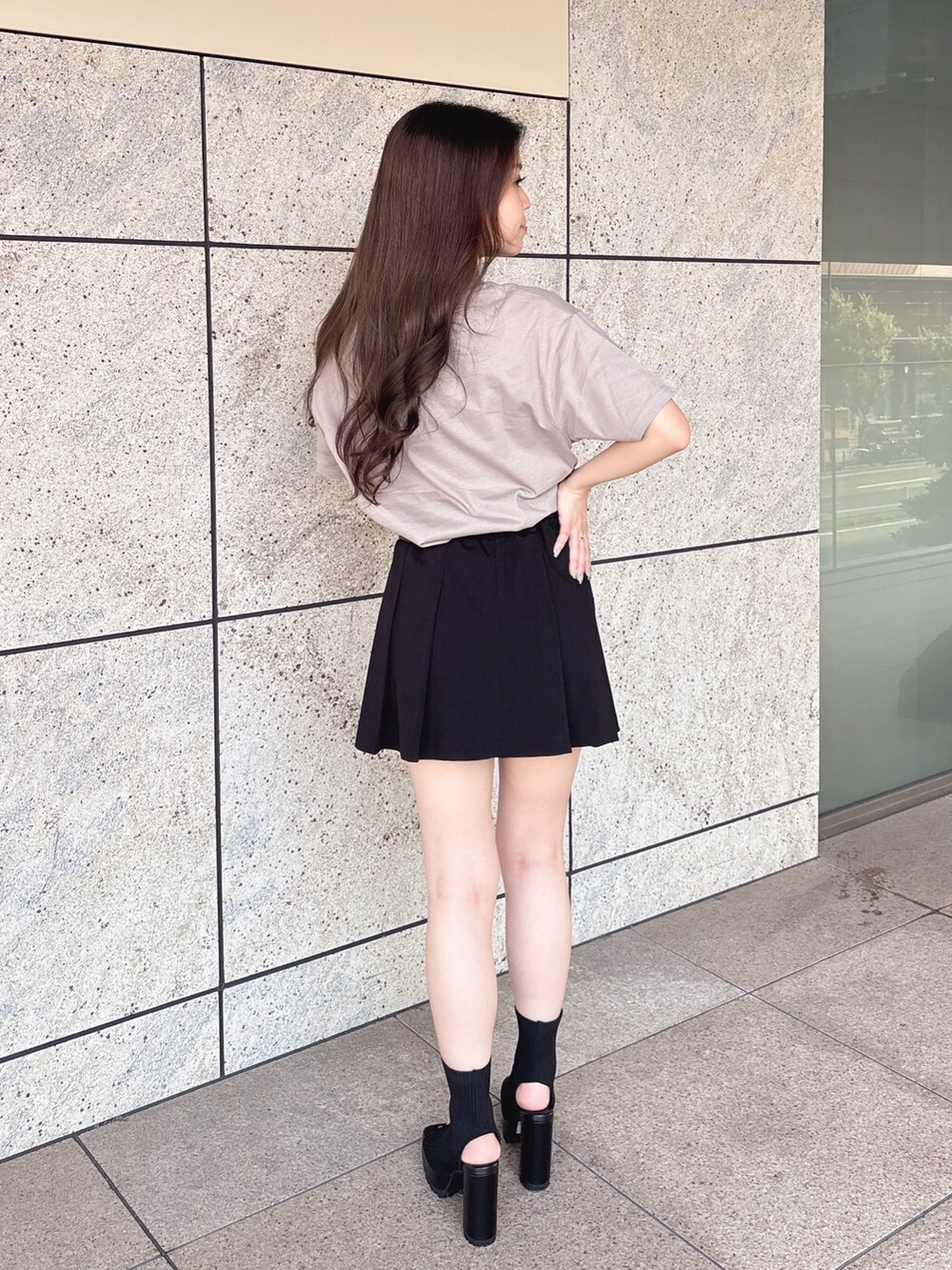 ベージュ系のTシャツ/カットソー、ブラック系のスカート、ブラック系のブーツを着用したレディースの夏コーディネートの4枚目の写真