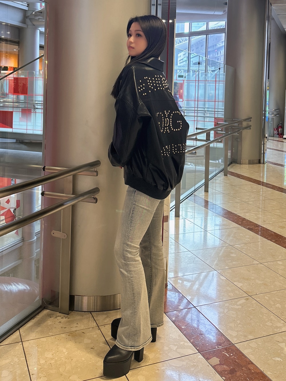 ブラック系のブルゾン、ブルー系のデニムパンツ、ブラック系のブーツを着用したレディースの春コーディネートの2枚目の写真