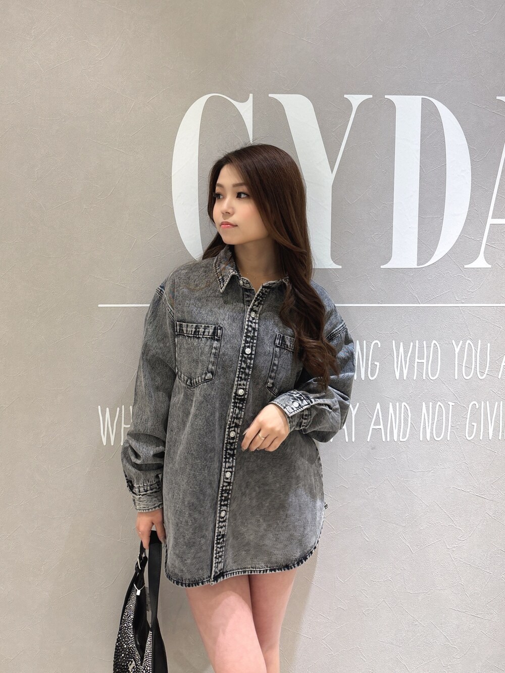 ブラック系のシャツ/ブラウス、ブラック系のブーツ、ブラック系のハンドバッグを着用したレディースの春コーディネートの6枚目の写真