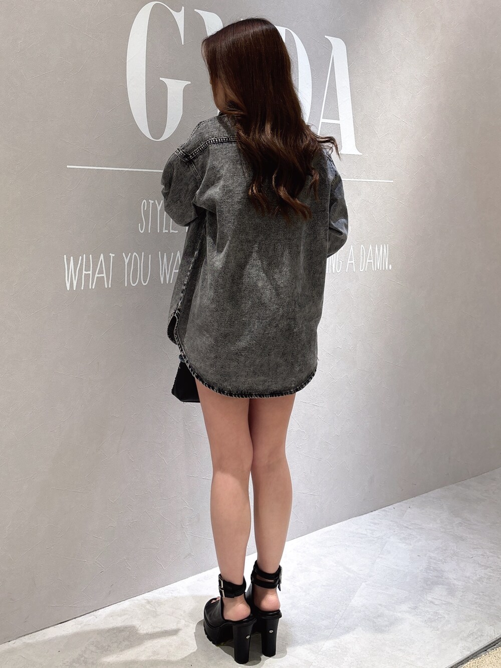 ブラック系のシャツ/ブラウス、ブラック系のブーツ、ブラック系のハンドバッグを着用したレディースの春コーディネートの4枚目の写真