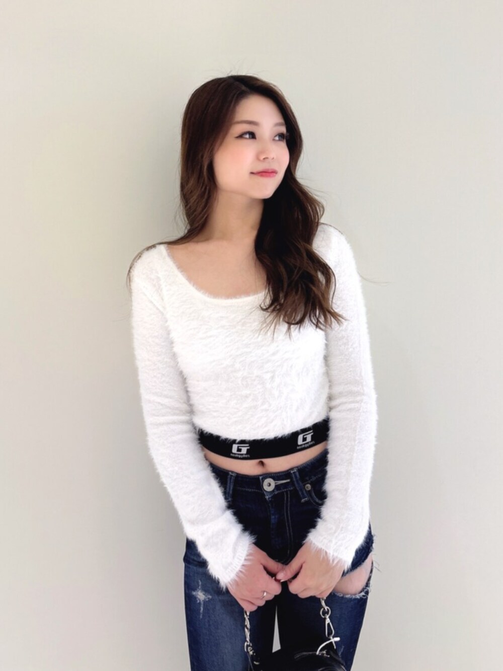 ホワイト系のパンプス、ブルー系のデニムパンツ、ブラック系のショルダーバッグを着用したレディースの冬コーディネートの6枚目の写真