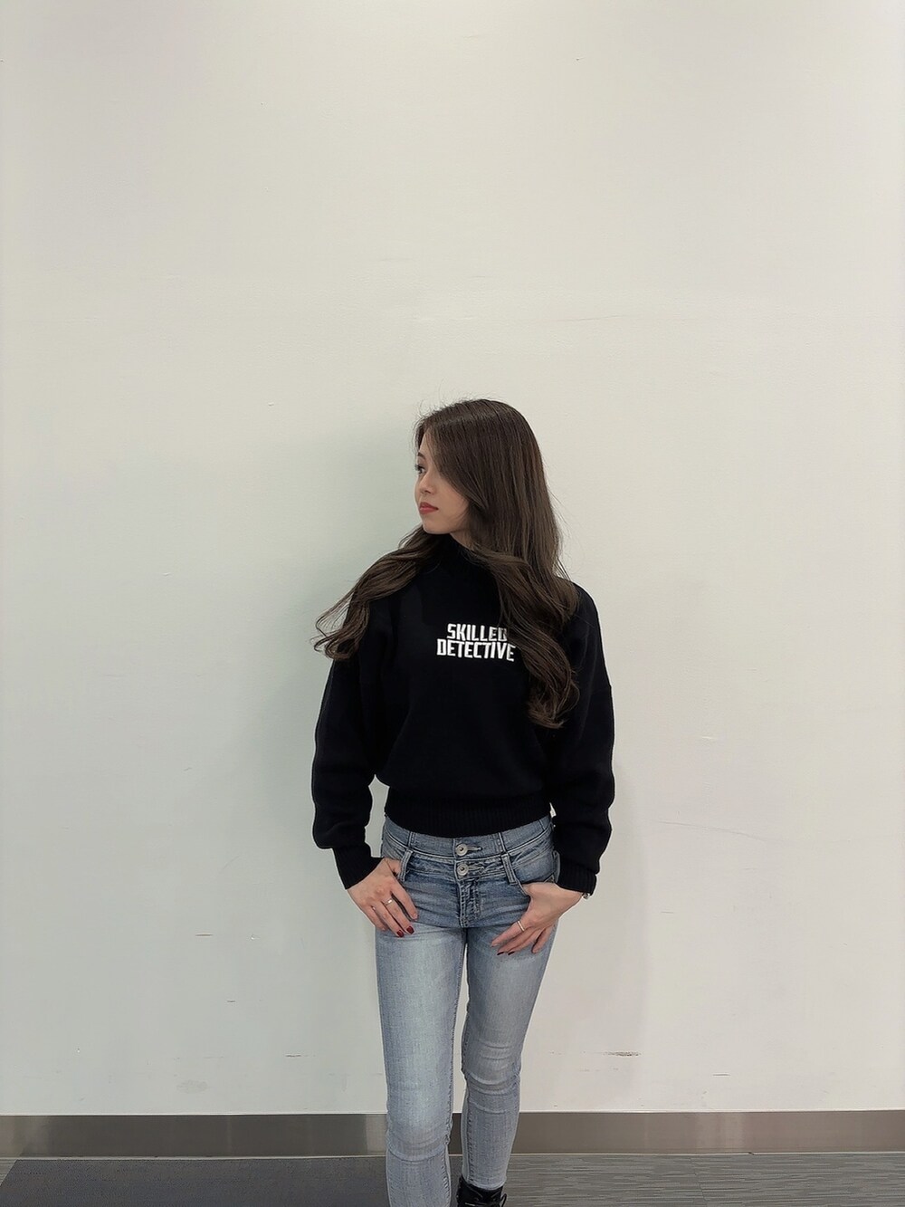 ブラック系のニット/セーター、ブルー系のデニムパンツ、ブラック系のブーツを着用したレディースの冬コーディネートの3枚目の写真