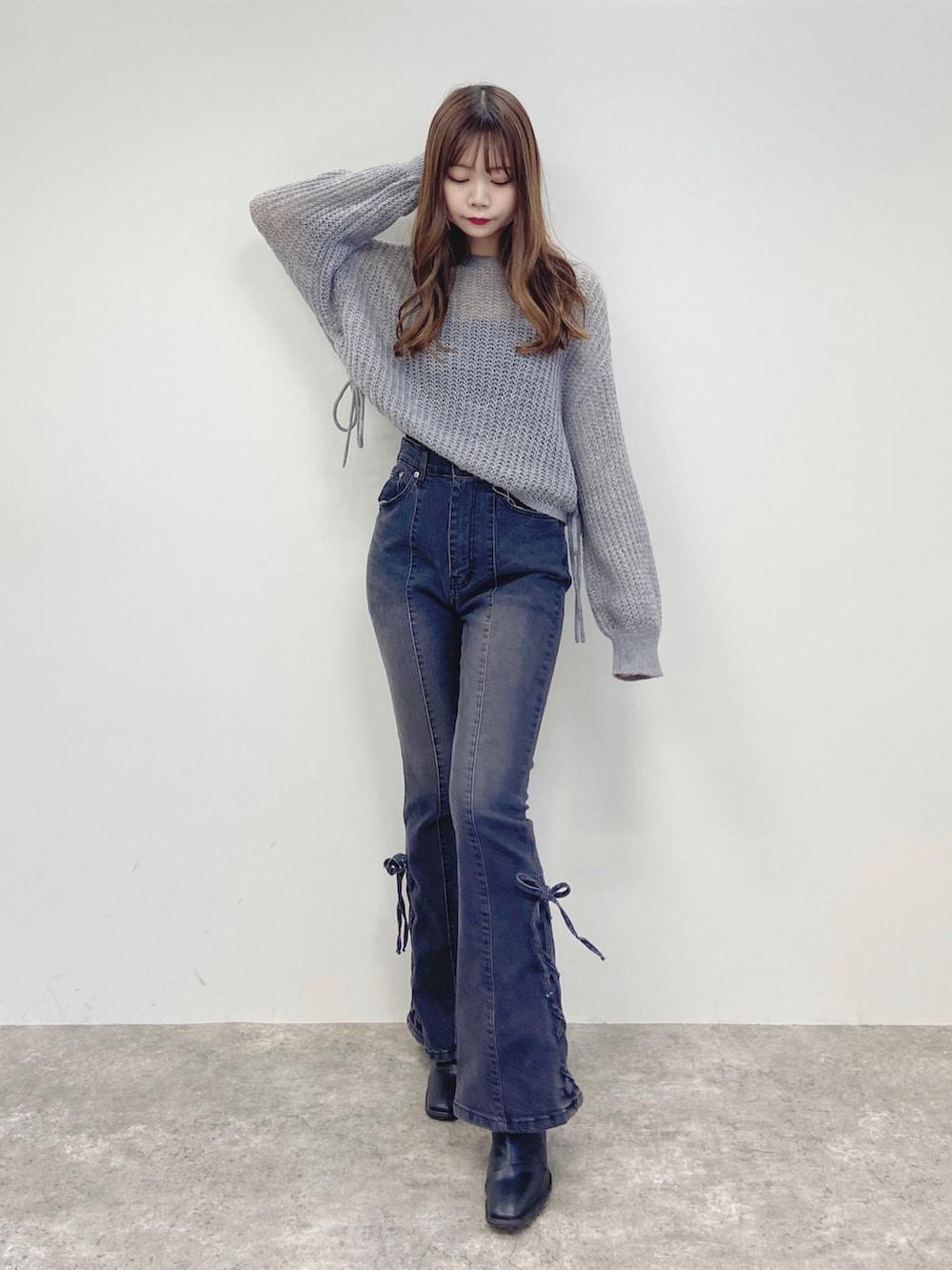 グレー系のデニムパンツ、グレー系のニット/セーターを着用したレディースの秋コーディネートの2枚目の写真
