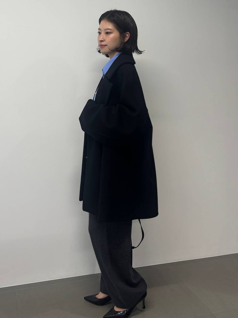 グレー系のその他パンツ、ブラック系のピーコート、グレー系のストール/ショールを着用したレディースの秋コーディネートの2枚目の写真