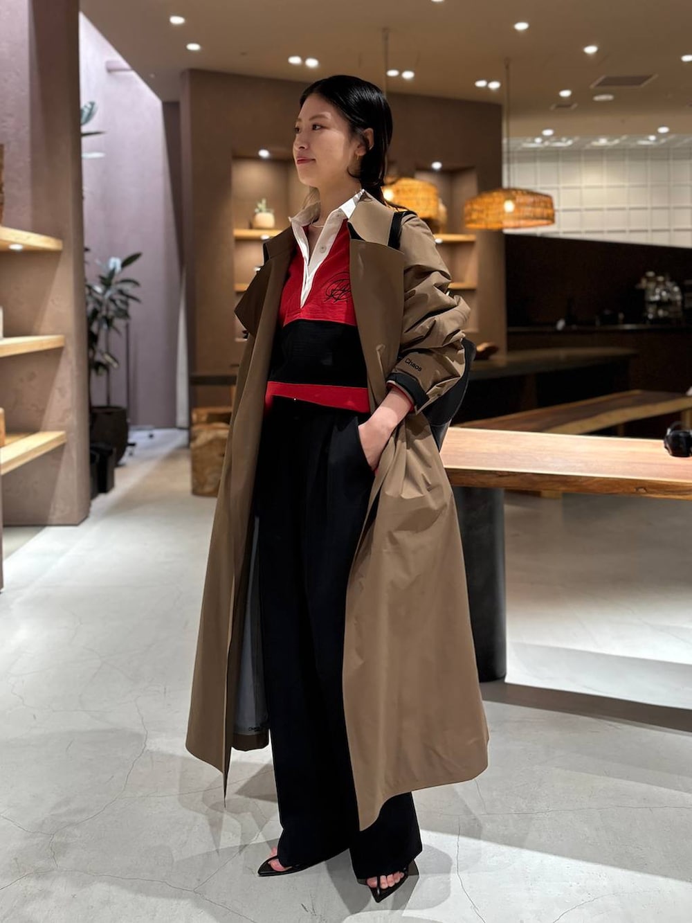 レッド系のスウェット、ベージュ系のトレンチコートを着用したレディースの冬コーディネートの2枚目の写真