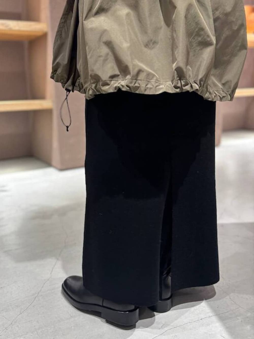 ブラック系のニット/セーター、グリーン系のブルゾン、ブラック系のスカートを着用したレディースの秋コーディネートの9枚目の写真