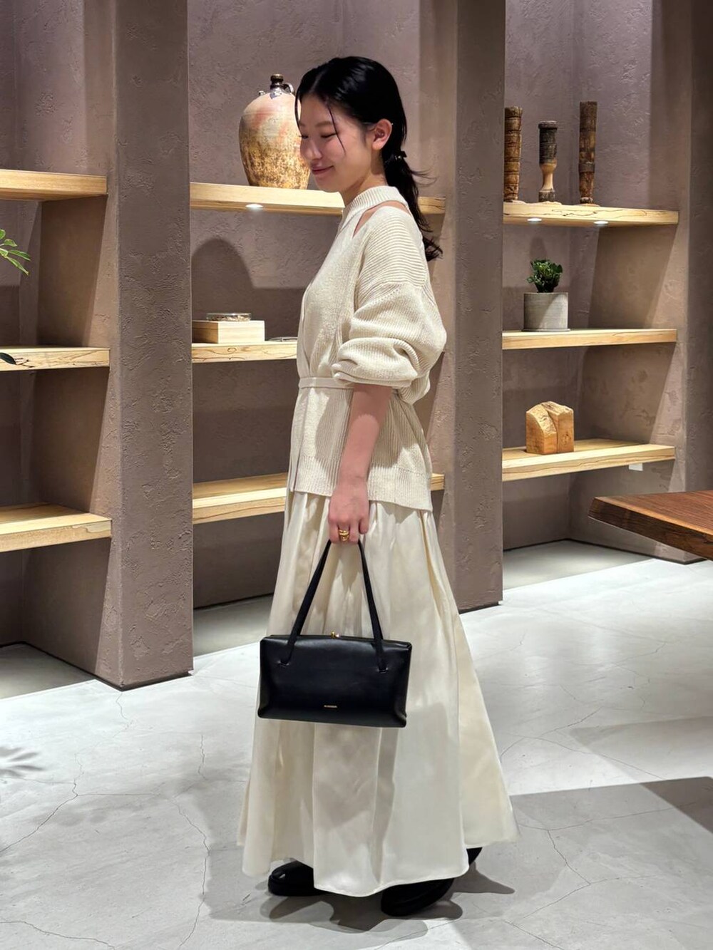 ホワイト系のカーディガン/ボレロ、ホワイト系のタンクトップ、ホワイト系のスカートを着用したレディースの冬コーディネートの4枚目の写真