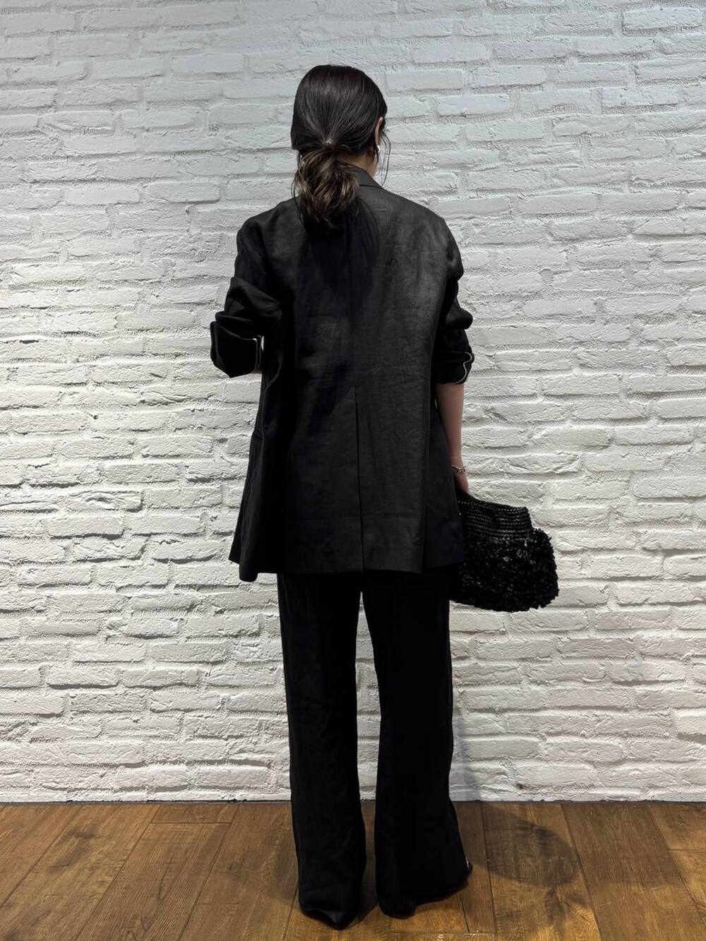 ブラック系のスラックス、ブラック系のテーラードジャケット、ブラウン系のTシャツ/カットソーを着用したレディースの春コーディネートの4枚目の写真