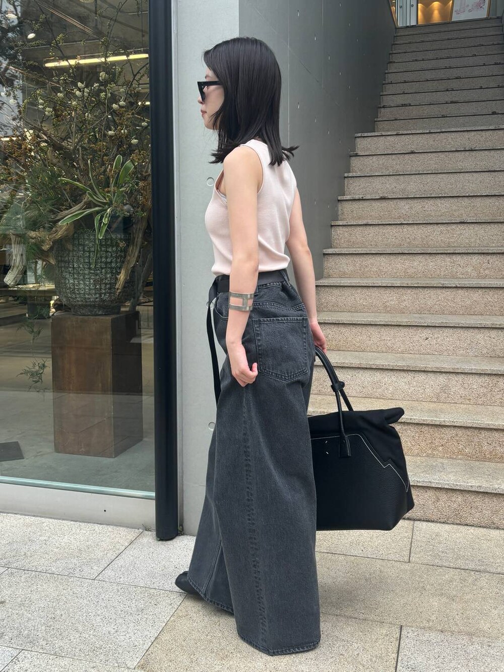 ピンク系のニット/セーター、ブラック系のデニムパンツを着用したレディースの春コーディネートの4枚目の写真