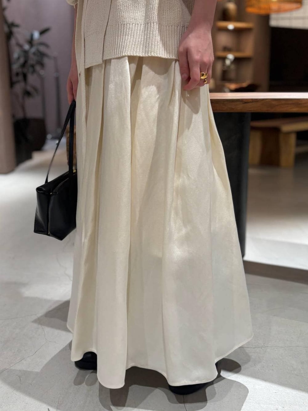 ホワイト系のカーディガン/ボレロ、ホワイト系のタンクトップ、ホワイト系のスカートを着用したレディースの冬コーディネートの7枚目の写真