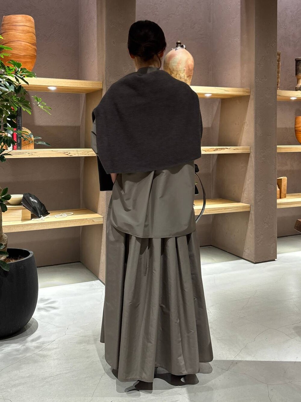 グレー系のニット/セーター、ブラウン系のシャツ/ブラウス、ブラウン系のスカートを着用したレディースの秋コーディネートの3枚目の写真