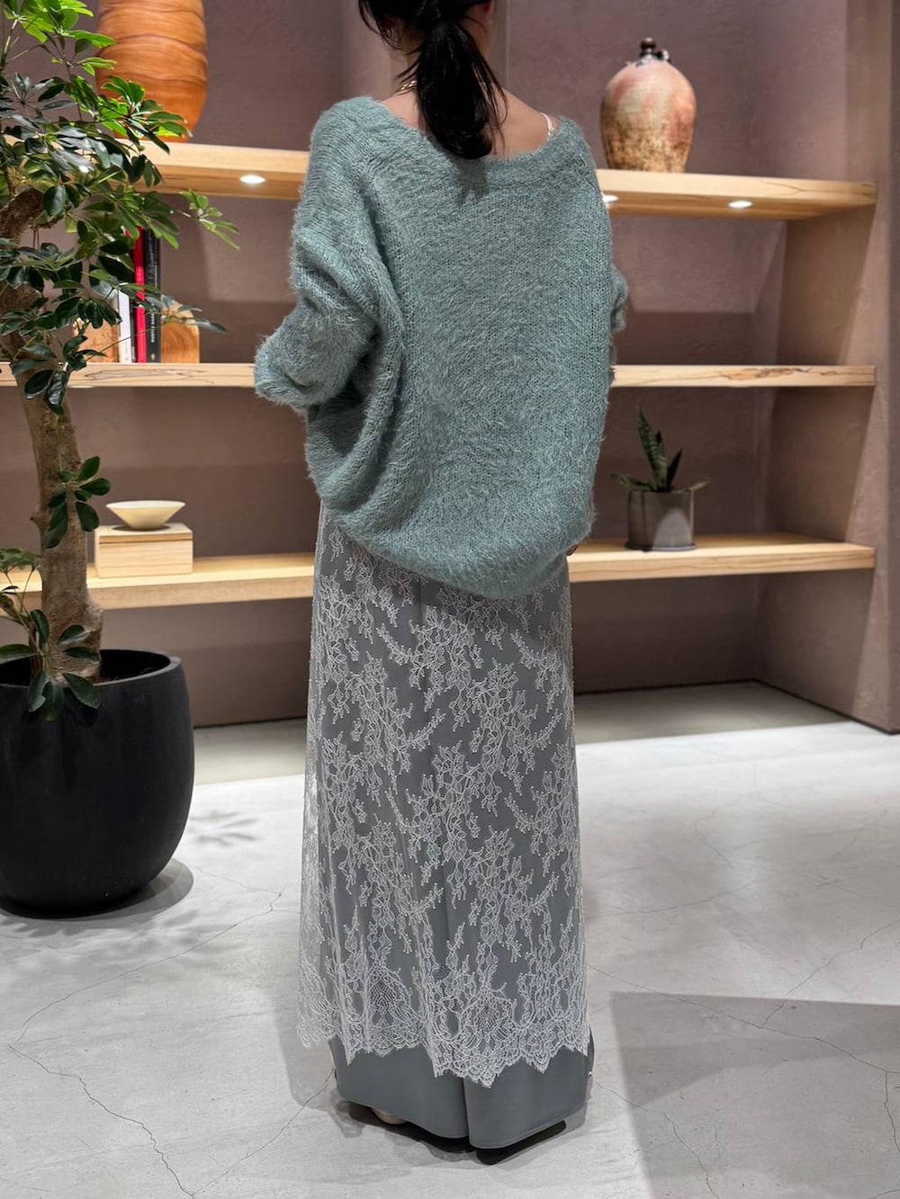 グレー系のスカート、グリーン系のニット/セーター、グリーン系のその他パンツを着用したレディースの秋コーディネートの7枚目の写真