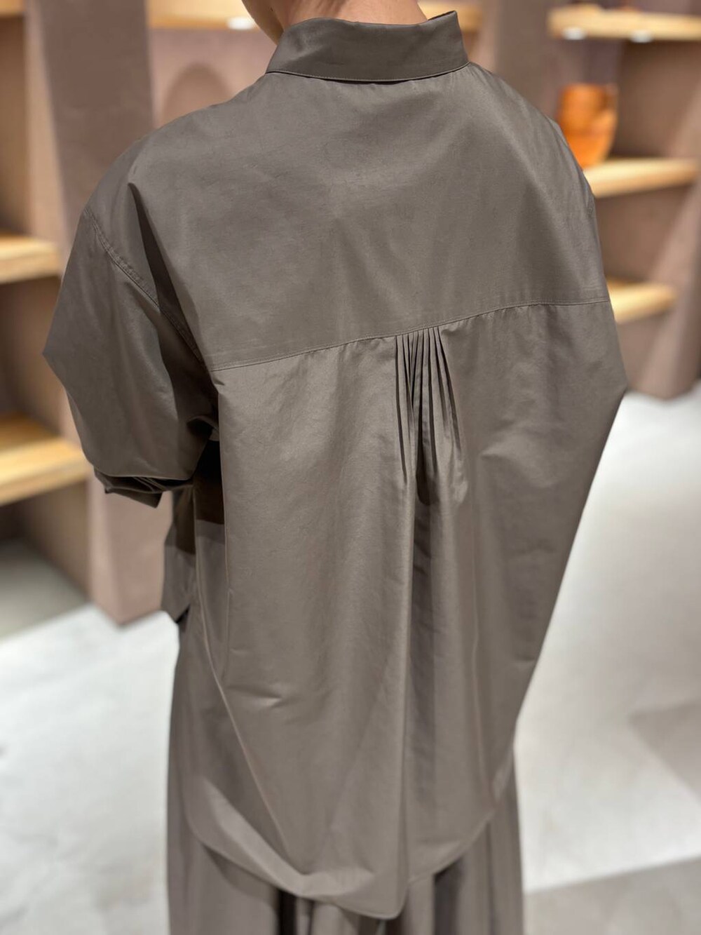 グレー系のニット/セーター、ブラウン系のシャツ/ブラウス、ブラウン系のスカートを着用したレディースの秋コーディネートの6枚目の写真