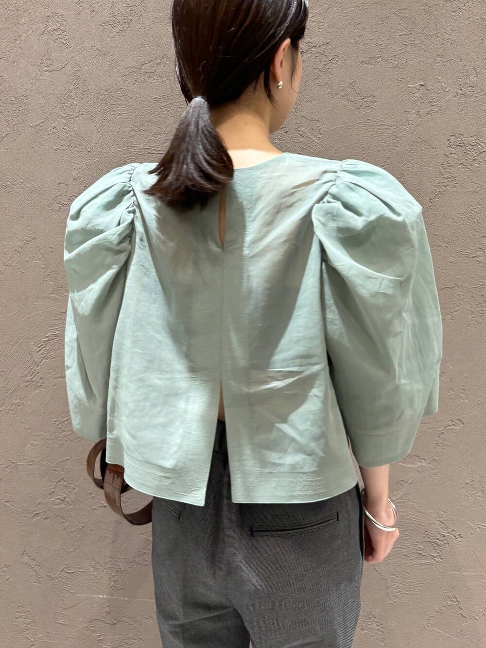 ブラック系のその他パンツ、グリーン系のシャツ/ブラウスを着用したレディースの春コーディネートの6枚目の写真