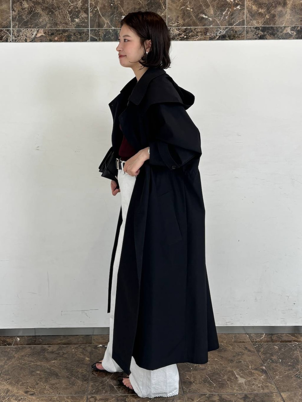 ホワイト系のデニムパンツ、レッド系のTシャツ/カットソー、ブルー系のトレンチコートを着用したレディースの秋コーディネートの2枚目の写真