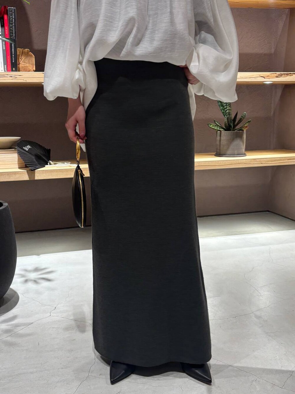 ブラック系のニット/セーター、グリーン系のスカートを着用したレディースの秋コーディネートの7枚目の写真