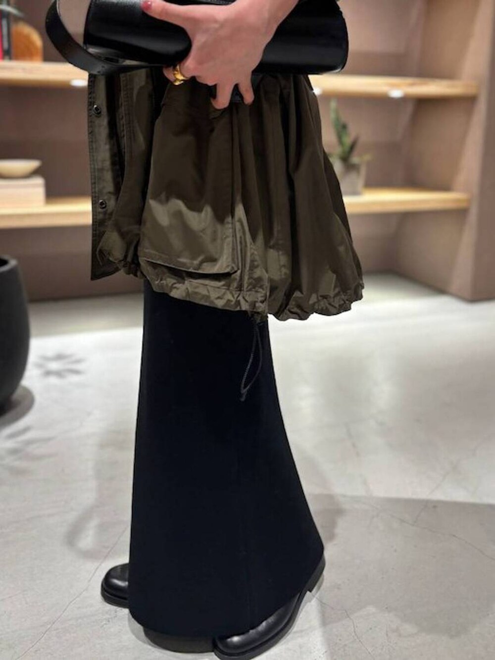 ブラック系のニット/セーター、グリーン系のブルゾン、ブラック系のスカートを着用したレディースの秋コーディネートの8枚目の写真