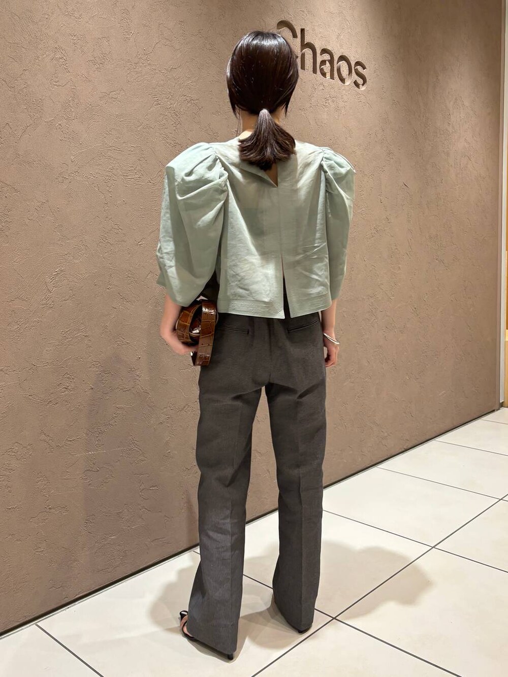 ブラック系のその他パンツ、グリーン系のシャツ/ブラウスを着用したレディースの春コーディネートの3枚目の写真