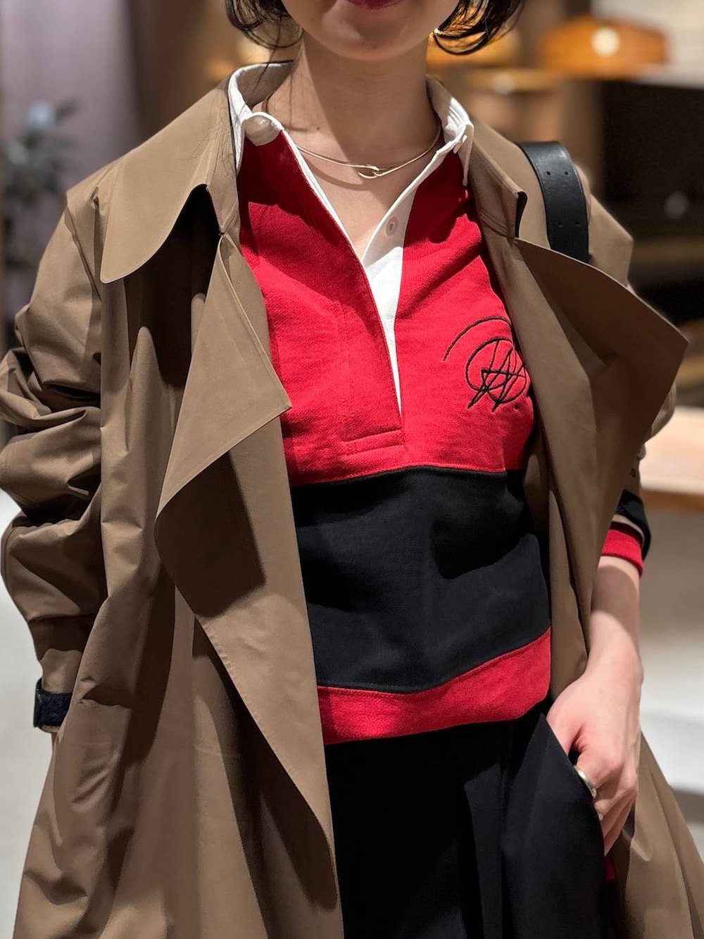 レッド系のスウェット、ベージュ系のトレンチコートを着用したレディースの冬コーディネートの3枚目の写真