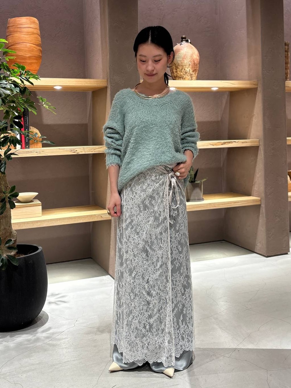 グレー系のスカート、グリーン系のニット/セーター、グリーン系のその他パンツを着用したレディースの秋コーディネートの4枚目の写真